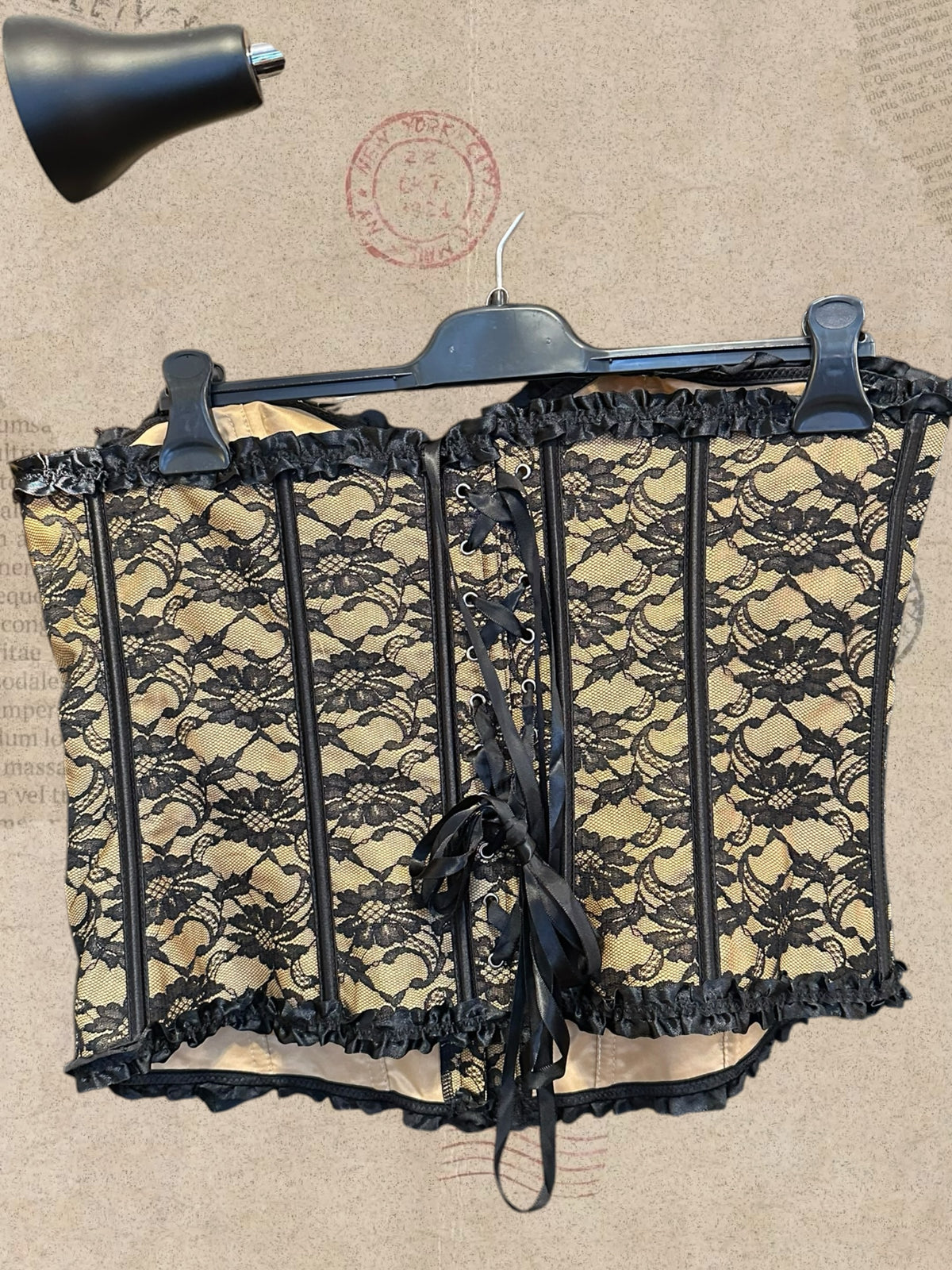 Victorian beige corset with black floral lace and satin bows. Adjustable lace-up back for a flattering fit. A romantic statement piece with gothic charm.