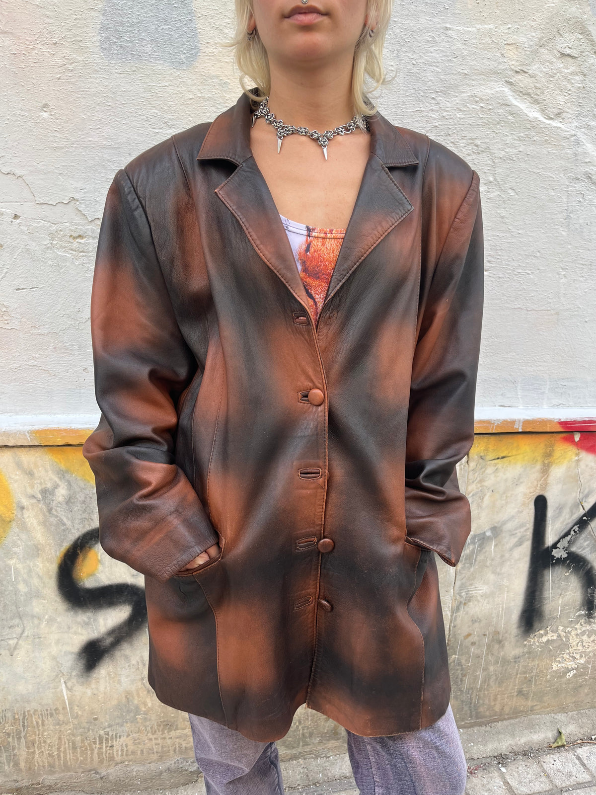 Oversized vintage leather blazer featuring a unique distressed brown and black finish. A statement piece with a relaxed fit, classic lapels, and button-front closure.