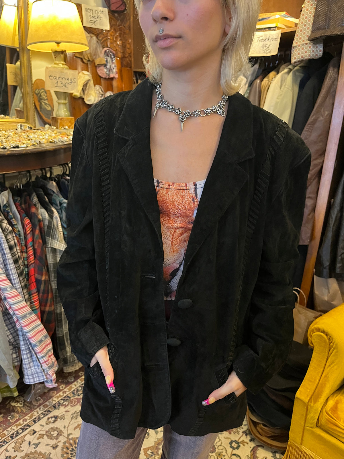 Vintage black suede blazer featuring intricate woven leather detailing along the front, shoulders, and back. Designed with a relaxed oversized fit, classic lapels, and understated button closure.