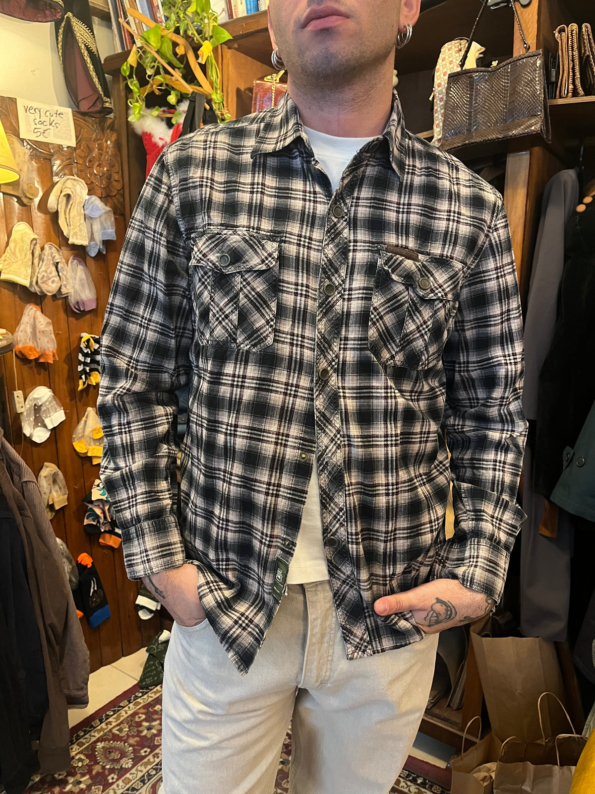 Vintage black and grey plaid flannel shirt featuring subtle red accents, snap buttons and double chest pockets. Relaxed fit with Western-inspired detailing for an effortless 90s grunge look