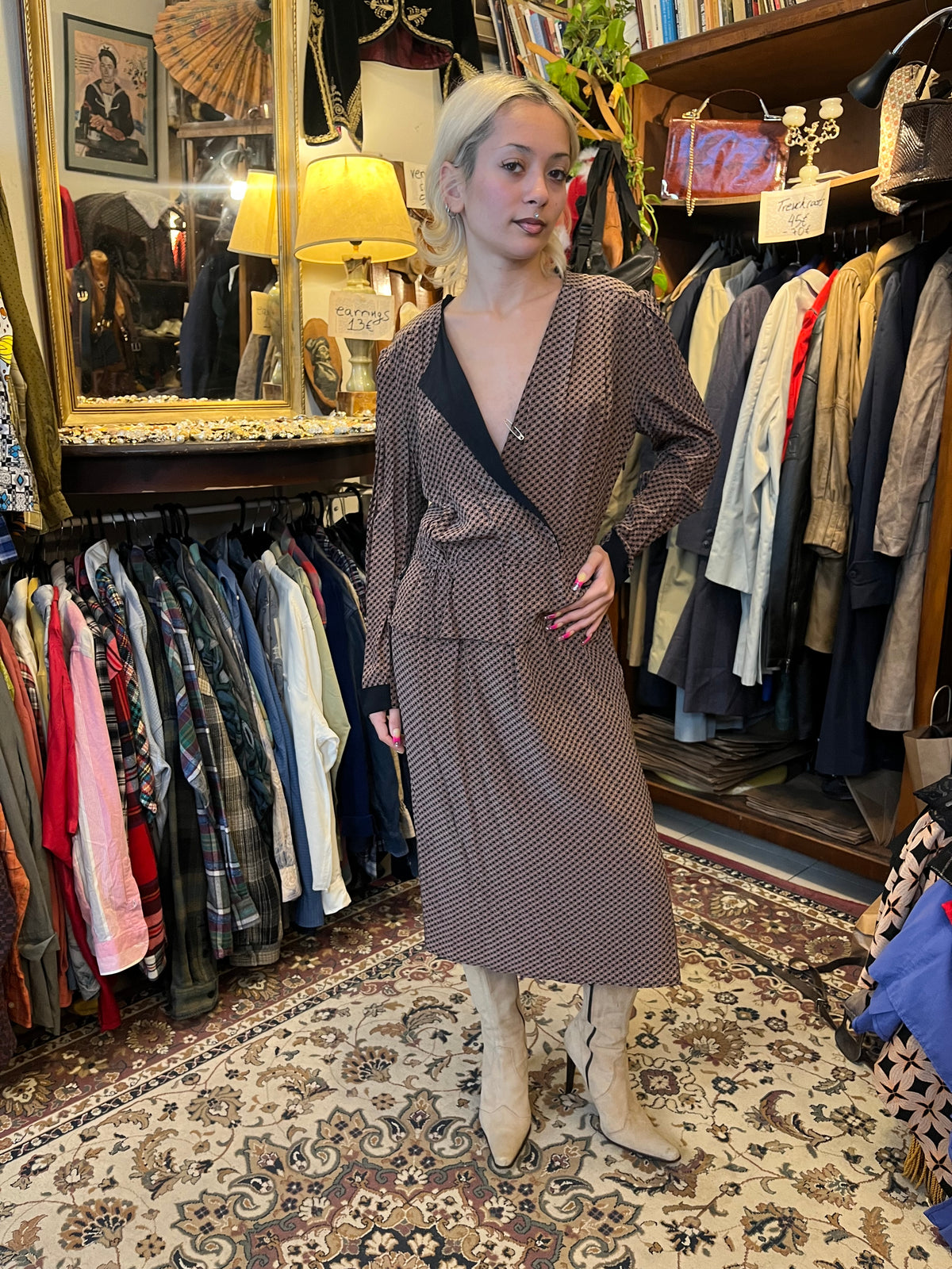 A sophisticated wrap-style midi dress featuring a geometric print, contrasting black lapels, and a flattering tie waist. Its fluid silhouette and deep V-neckline create an effortlessly elegant, timeless look