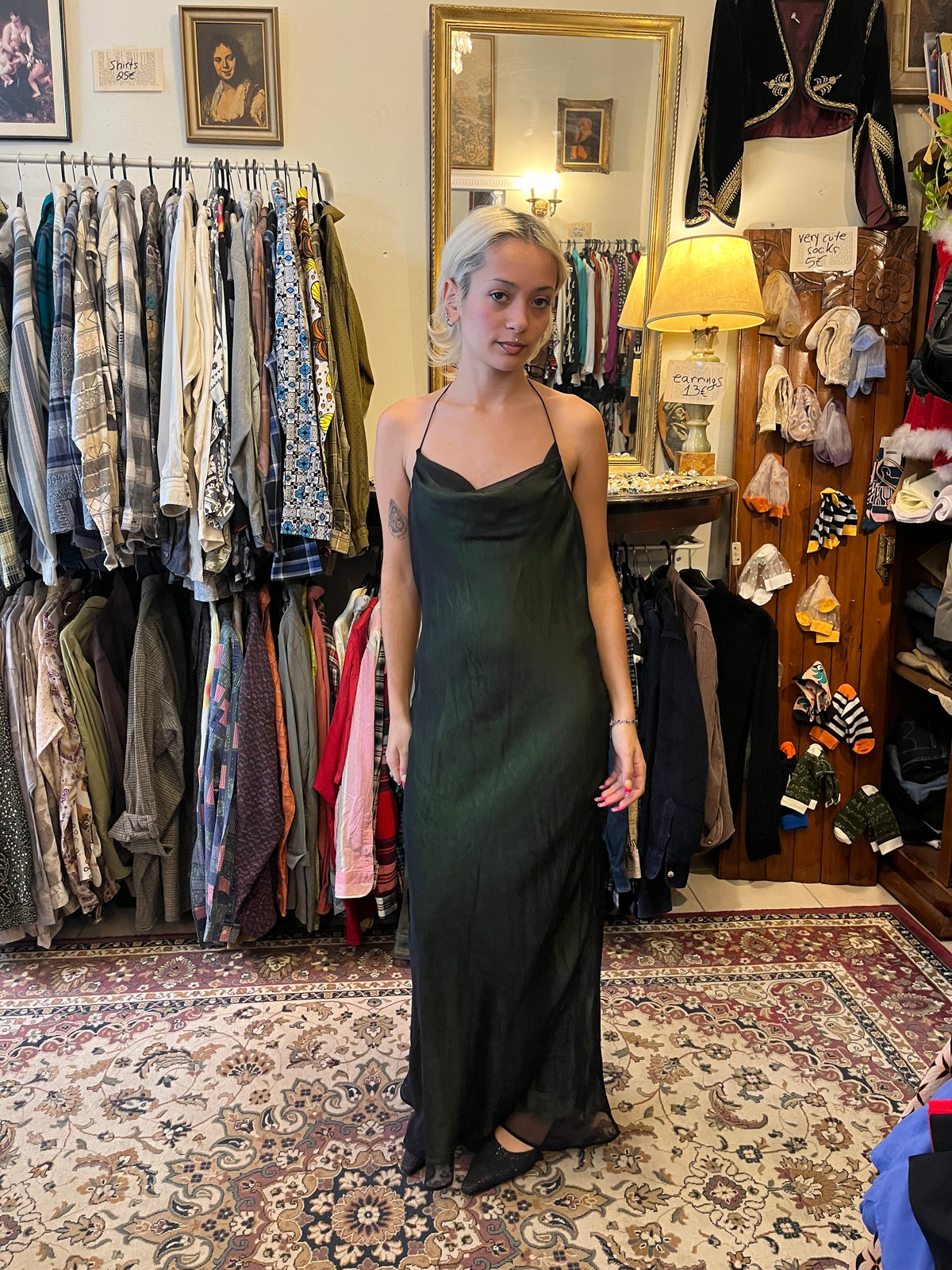 Elegant dark green maxi slip dress with a soft cowl neckline and delicate halter straps. Its fluid, semi-sheer silhouette creates an effortlessly feminine and sophisticated look.