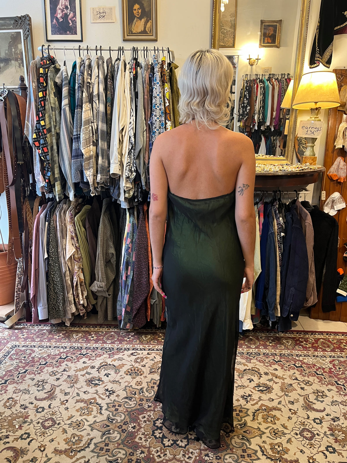 Elegant dark green maxi slip dress with a soft cowl neckline and delicate halter straps. Its fluid, semi-sheer silhouette creates an effortlessly feminine and sophisticated look.