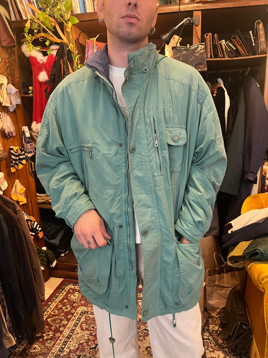 Vintage forest-green padded jacket with a relaxed oversized fit and subtle sheen.
Features brass-tone snap buttons, roomy pockets, and an adjustable drawstring hem