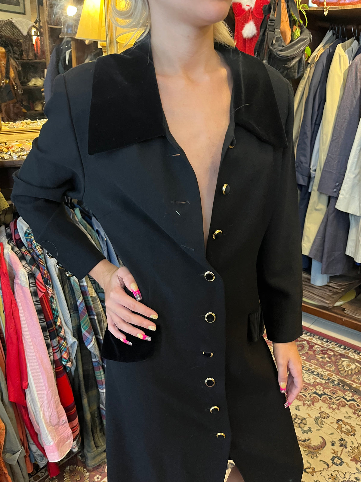 Elegant vintage black midi coat dress featuring a statement velvet collar and gold-tone buttons. Tailored silhouette with velvet pocket details for a timeless, sophisticated look.