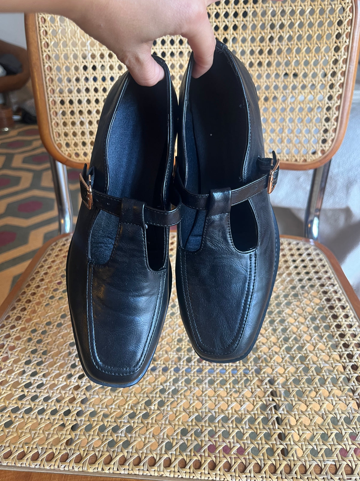 Classic black Mary Jane shoes with a T-strap, gold-tone buckle and a chic low block heel