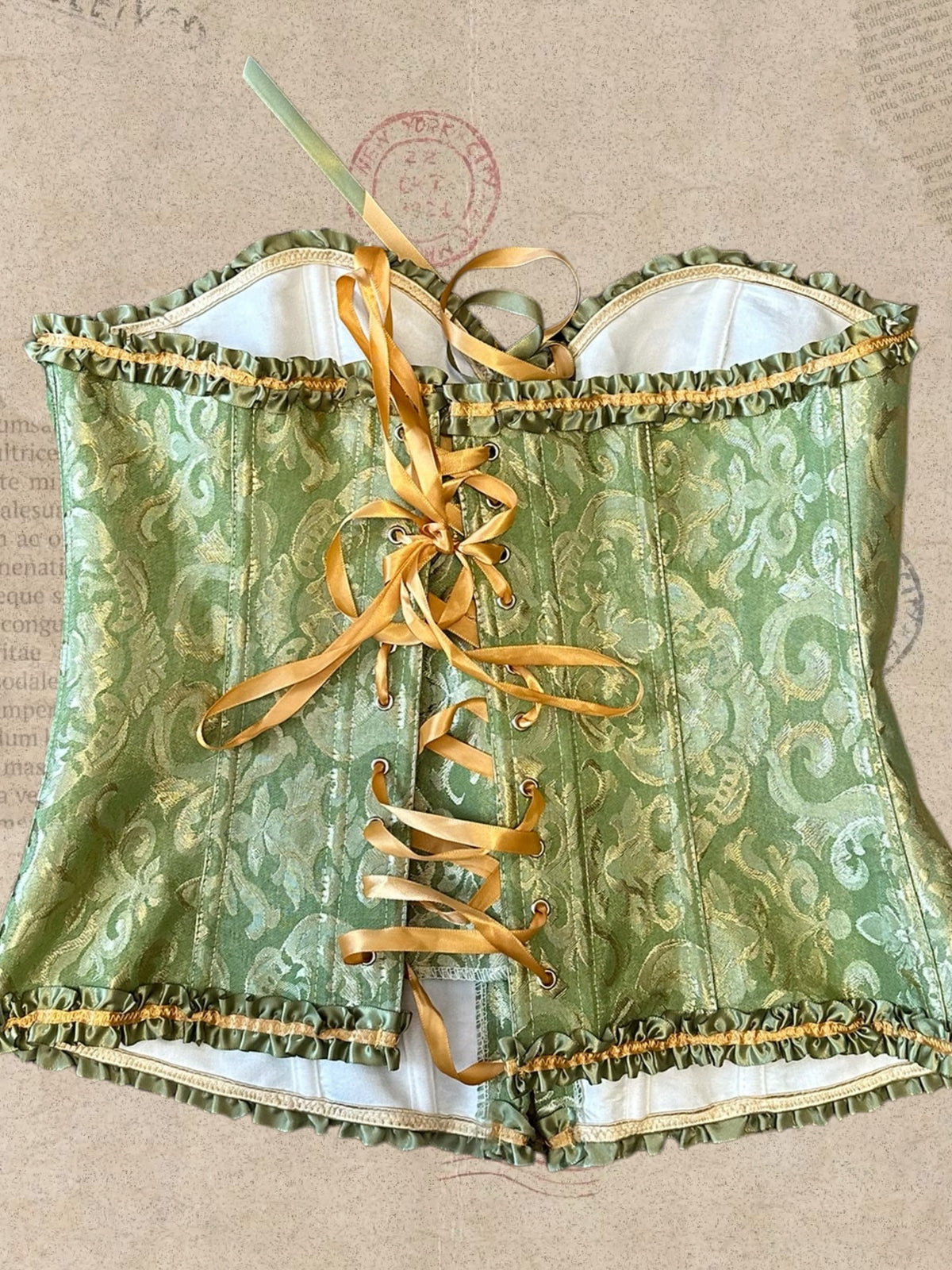 Victorian sage green corset with gold brocade and satin ruffles. Adjustable lace-up back for a flattering fit. A romantic statement piece with vintage charm.