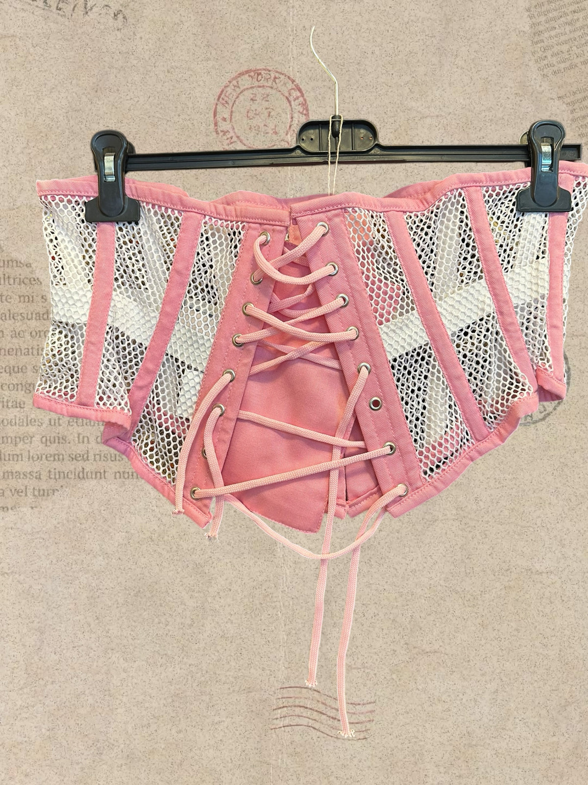 Pink and white mesh corset with floral details. Front hook closures and lace-up back. Cute, romantic style.