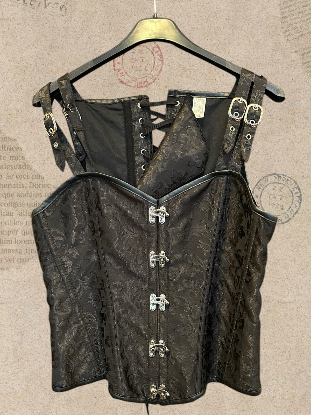 Black brocade corset with elegant floral patterns. Silver clasps, buckle straps and adjustable lace-up back. A bold gothic Victorian statement piece.