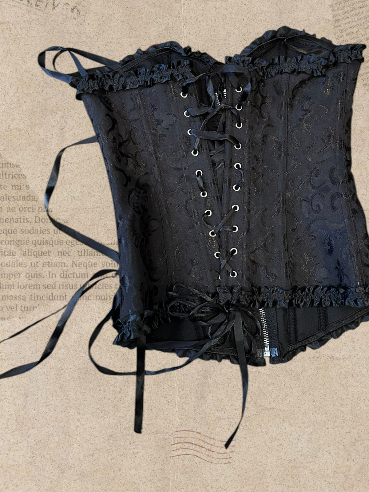 Black floral brocade corset with delicate ruffles. Front zipper and adjustable lace-up back. Elegant gothic Victorian style.