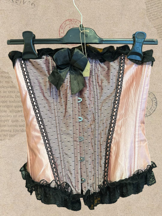 Romantic blush pink satin corset with black lace ruffles. Features adjustable ribbon lacing and delicate bow details. A dreamy Victorian-inspired statement piece.