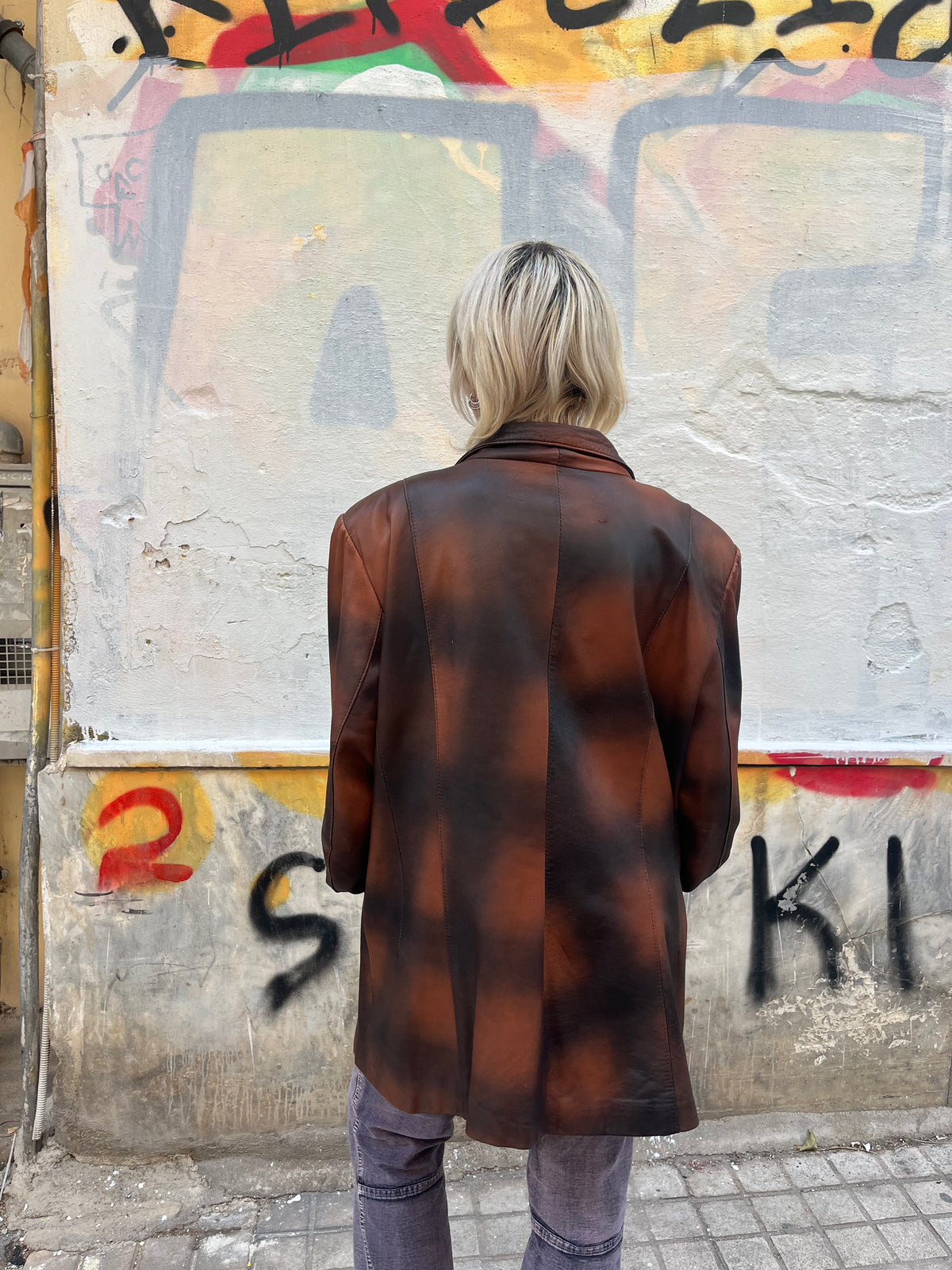 Oversized vintage leather blazer featuring a unique distressed brown and black finish. A statement piece with a relaxed fit, classic lapels, and button-front closure.