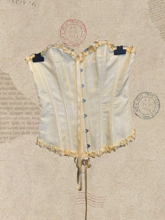 Victorian satin corset with delicate floral details and romantic ruffles. Features an adjustable lace-up back for a perfect fit. A timeless piece for dreamy, feminine looks.