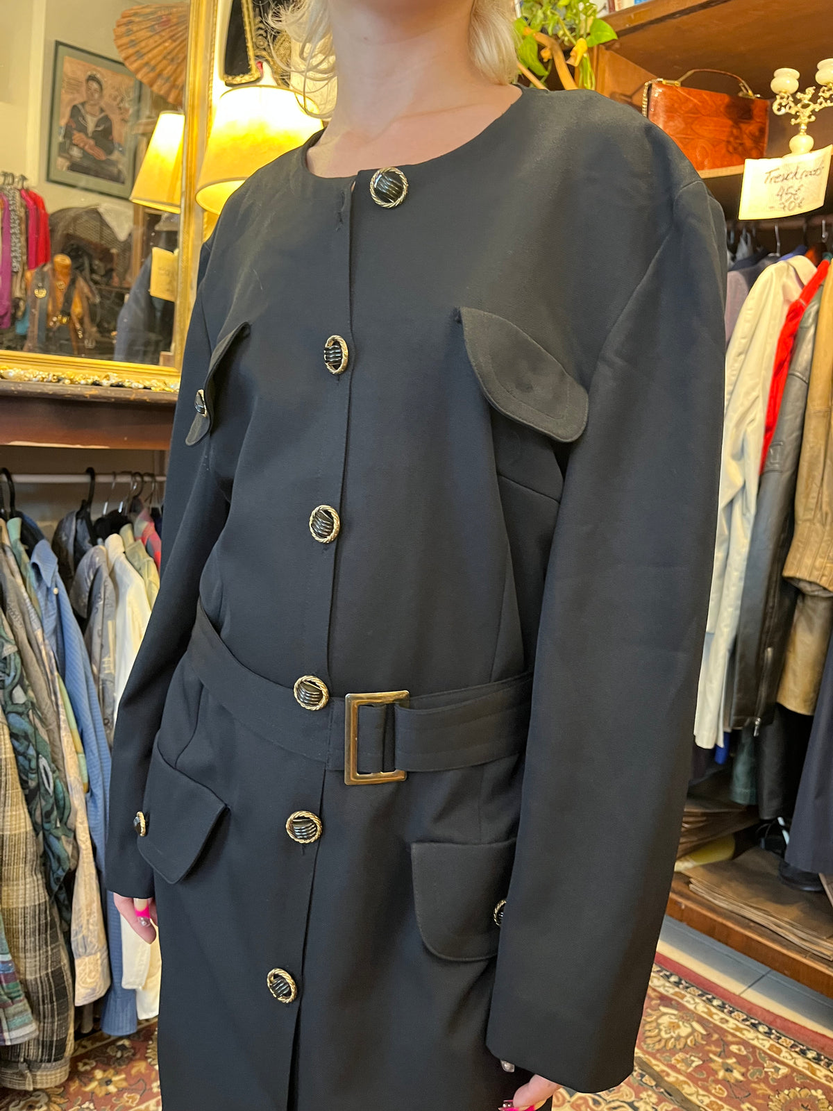 Vintage black midi coat dress featuring statement gold-tone buttons, multiple flap pockets and a matching waist belt. A structured, timeless silhouette with an elegant military-inspired feel.