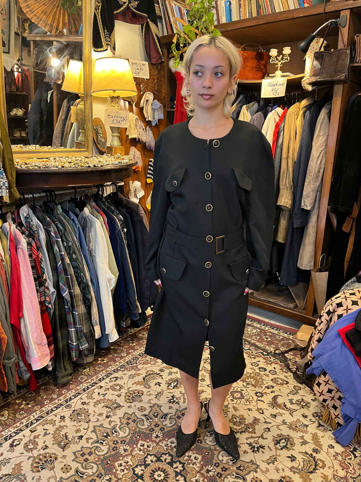 Vintage black midi coat dress featuring statement gold-tone buttons, multiple flap pockets and a matching waist belt. A structured, timeless silhouette with an elegant military-inspired feel.