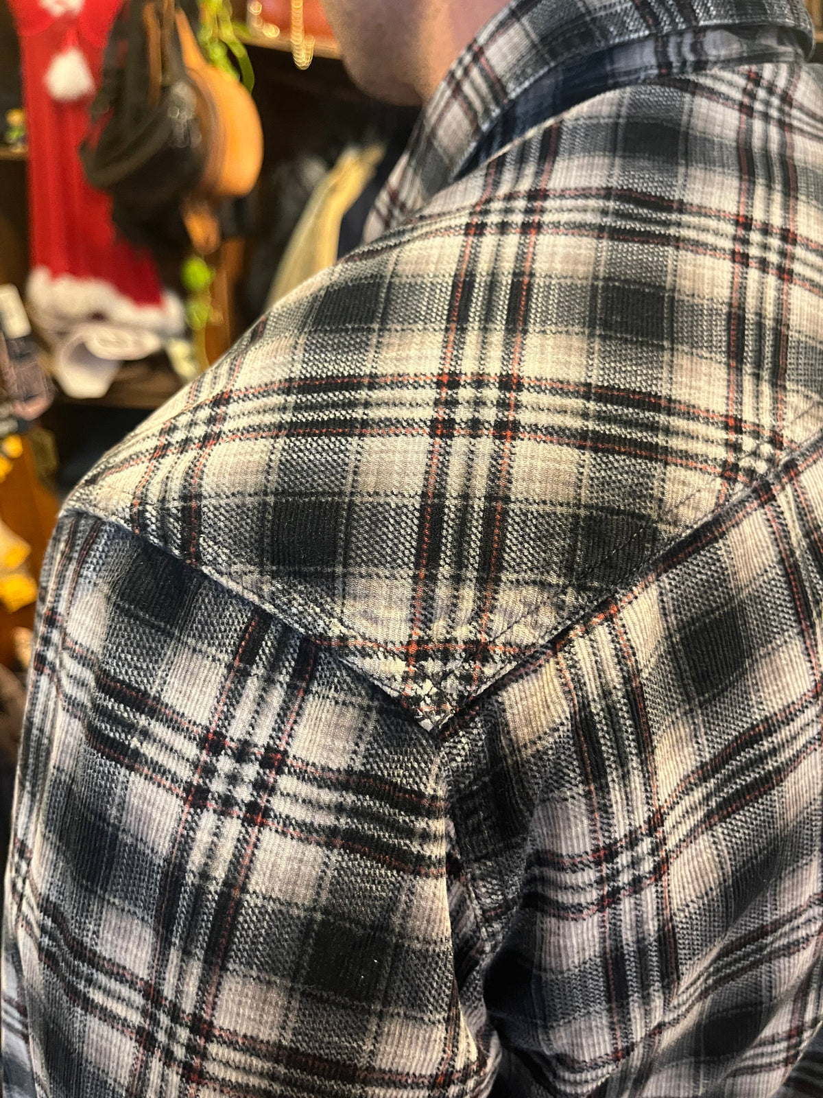 Vintage black and grey plaid flannel shirt featuring subtle red accents, snap buttons and double chest pockets. Relaxed fit with Western-inspired detailing for an effortless 90s grunge look
