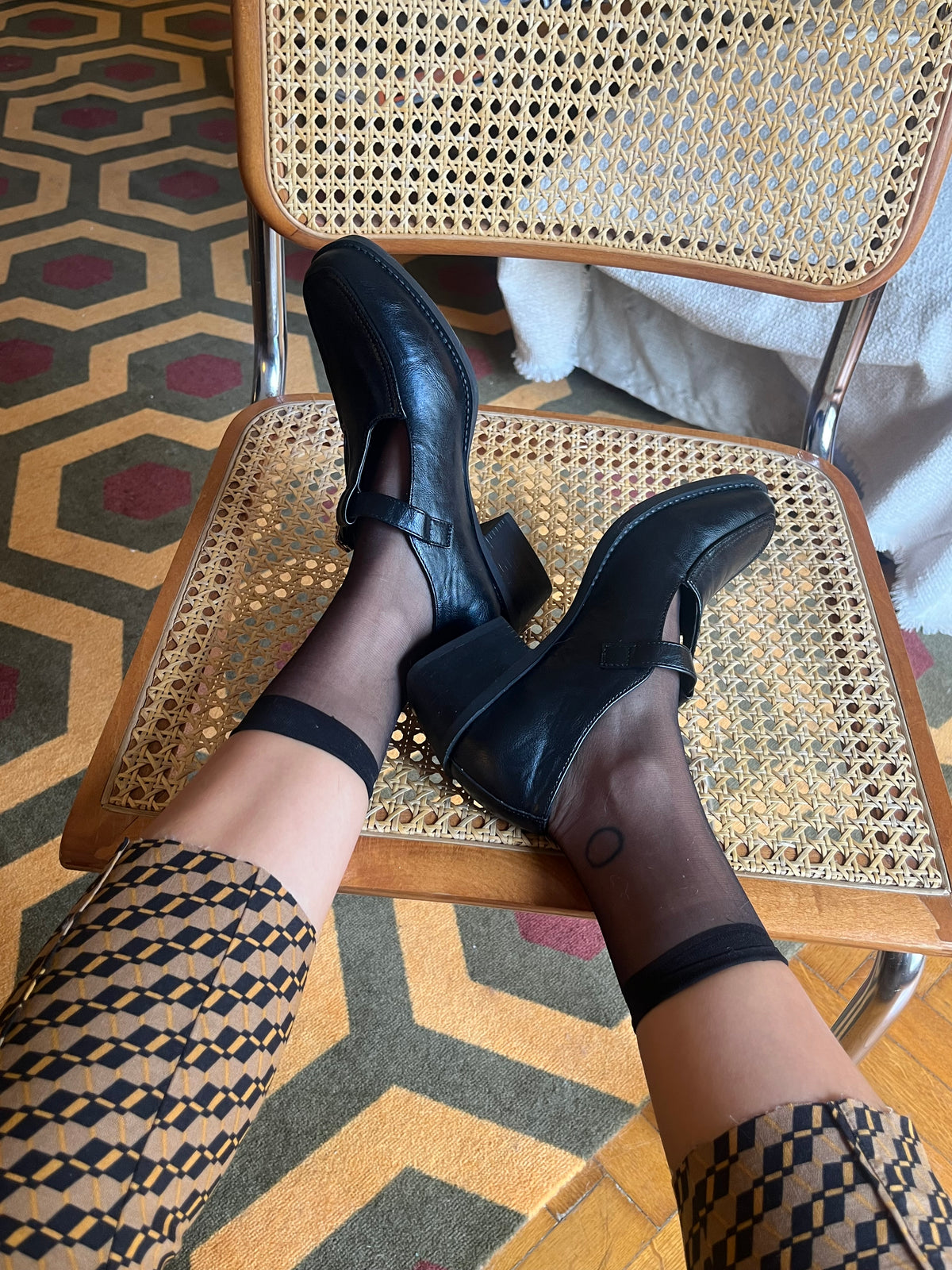 Classic black Mary Jane shoes with a T-strap, gold-tone buckle and a chic low block heel