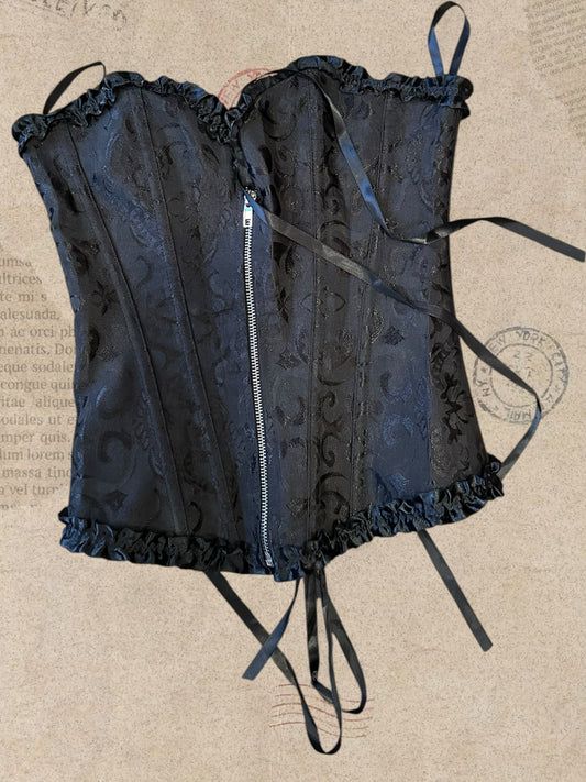 Black floral brocade corset with delicate ruffles. Front zipper and adjustable lace-up back. Elegant gothic Victorian style.