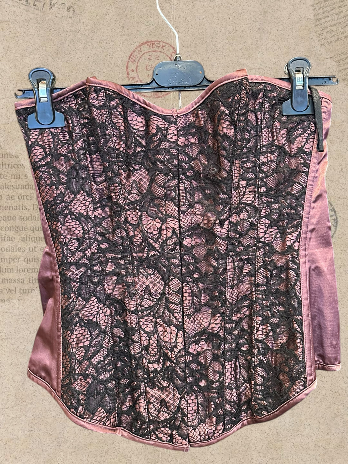 Dusty rose satin corset with intricate black floral lace. Adjustable lace-up back for a flattering fit. A romantic statement piece with gothic charm.