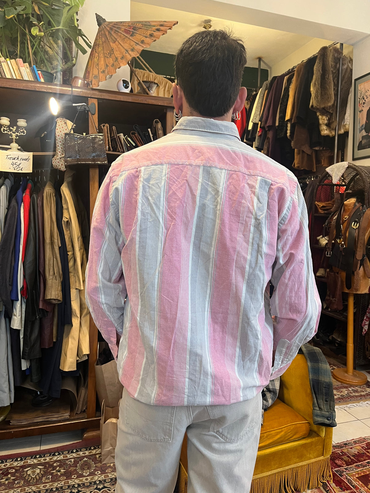 Vintage Lacoste striped button-down shirt in soft pink, grey and white tones, featuring the iconic crocodile logo on the chest pocket. Relaxed fit with a classic button-down collar for an effortless retro look.
