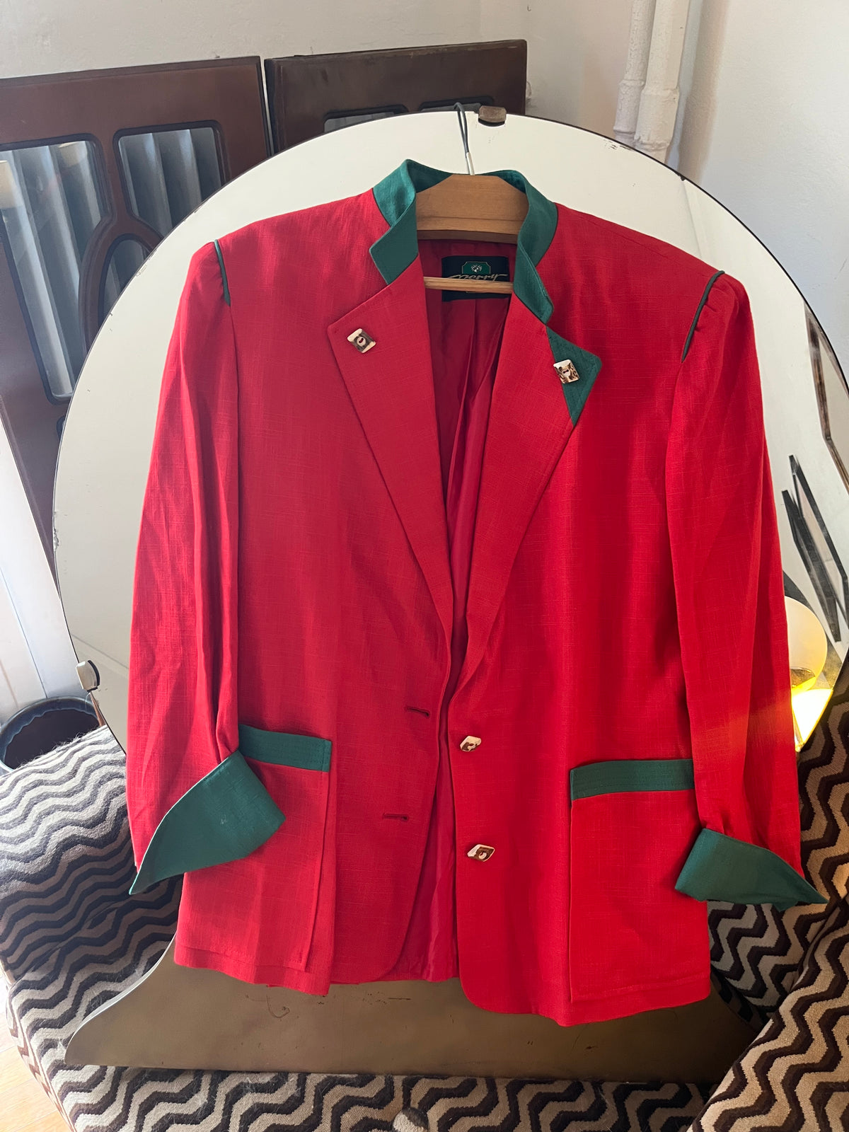 Vintage red blazer with contrasting green details and statement gold-tone buttons. Features structured shoulders and an oversized ’80s-inspired silhouette