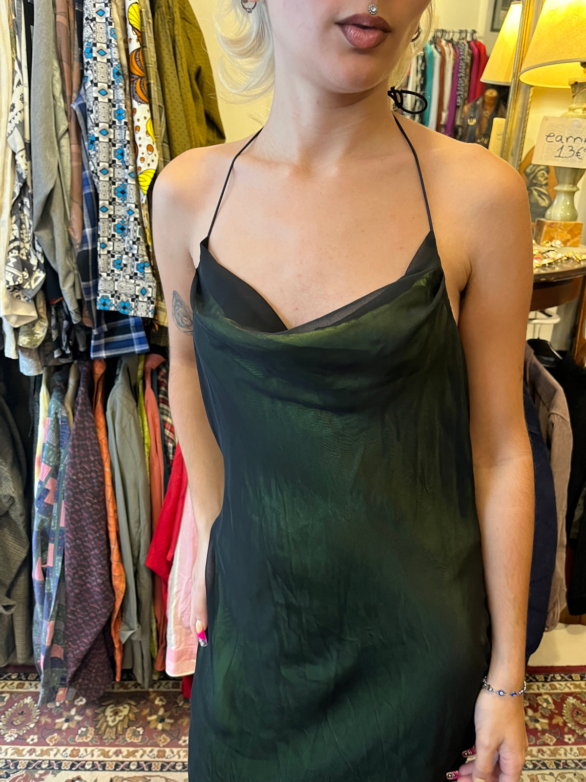 Elegant dark green maxi slip dress with a soft cowl neckline and delicate halter straps. Its fluid, semi-sheer silhouette creates an effortlessly feminine and sophisticated look.
