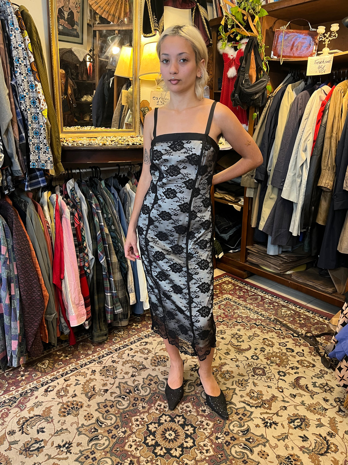 Elegant black lace midi dress with a contrasting silver lining, delicate floral detailing and slim straps. The fitted silhouette creates a timeless, feminine look with a romantic vintage feel