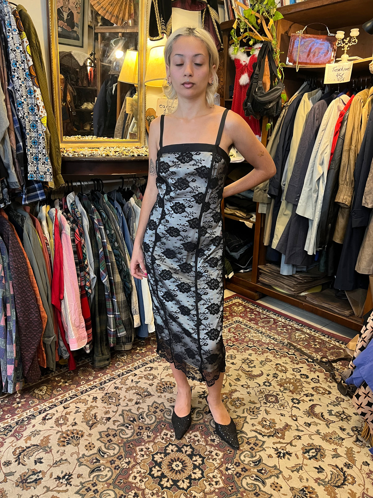 Elegant black lace midi dress with a contrasting silver lining, delicate floral detailing and slim straps. The fitted silhouette creates a timeless, feminine look with a romantic vintage feel