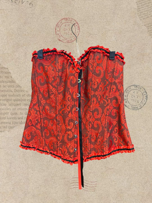 Victorian-inspired red corset with intricate brocade patterns and satin ruffles. Features front hook closure and a flattering, structured silhouette. A romantic statement piece with gothic elegance.