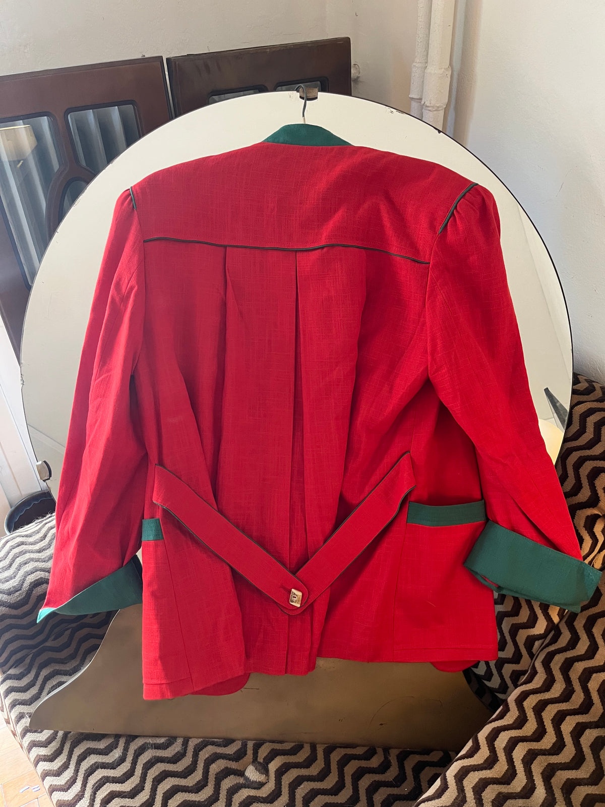 Vintage red blazer with contrasting green details and statement gold-tone buttons. Features structured shoulders and an oversized ’80s-inspired silhouette
