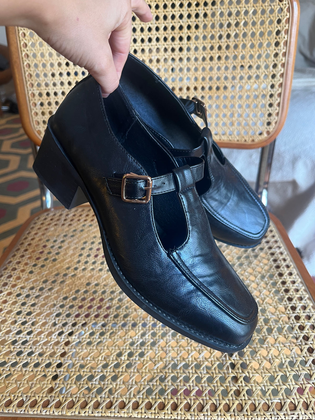 Classic black Mary Jane shoes with a T-strap, gold-tone buckle and a chic low block heel