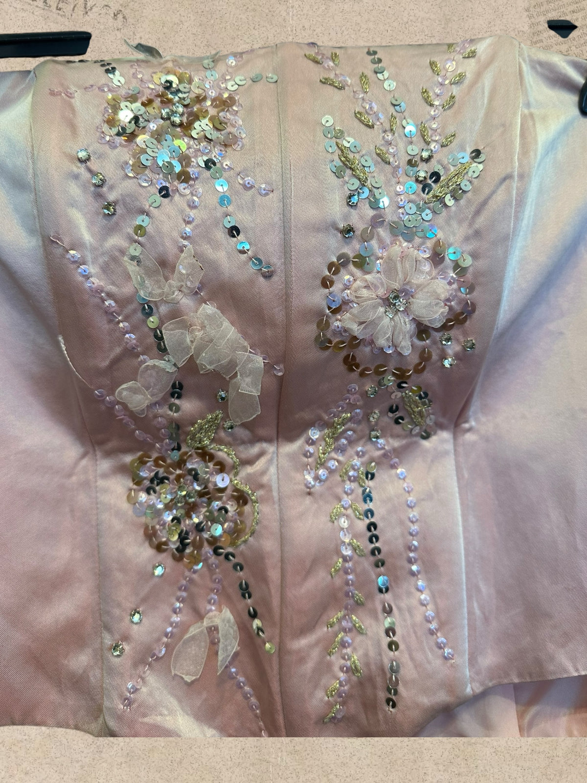 Blush pink satin corset with sparkling sequins and floral details. Side lace-up ties and back zipper. Romantic, elegant style.