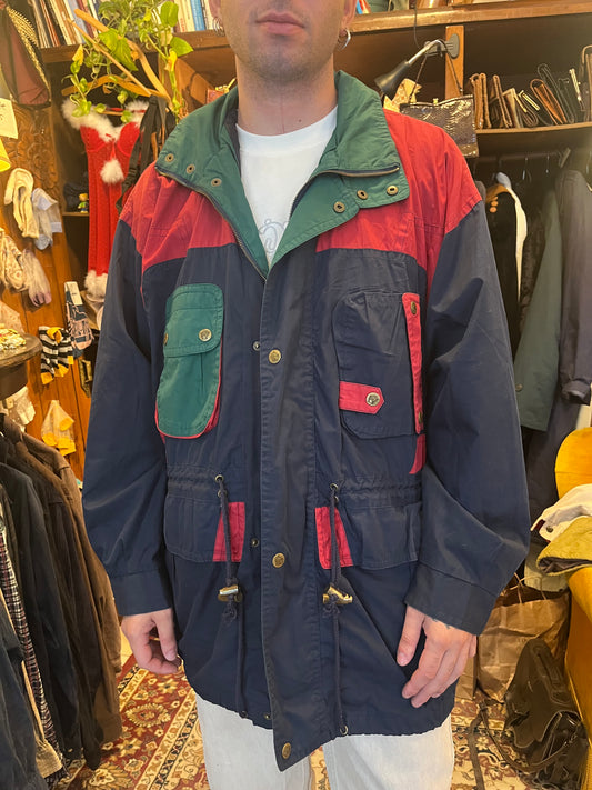 Vintage color-block parka in navy, red, and forest green, featuring an oversized relaxed fit and bold retro outdoor styling. Detailed with multiple utility pockets, metal hardware, a high zip collar, adjustable drawstring waist, and a distinctive color-bl