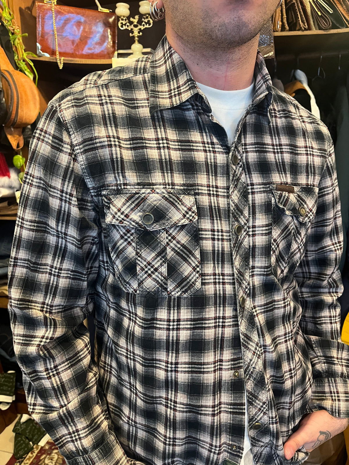 Vintage black and grey plaid flannel shirt featuring subtle red accents, snap buttons and double chest pockets. Relaxed fit with Western-inspired detailing for an effortless 90s grunge look