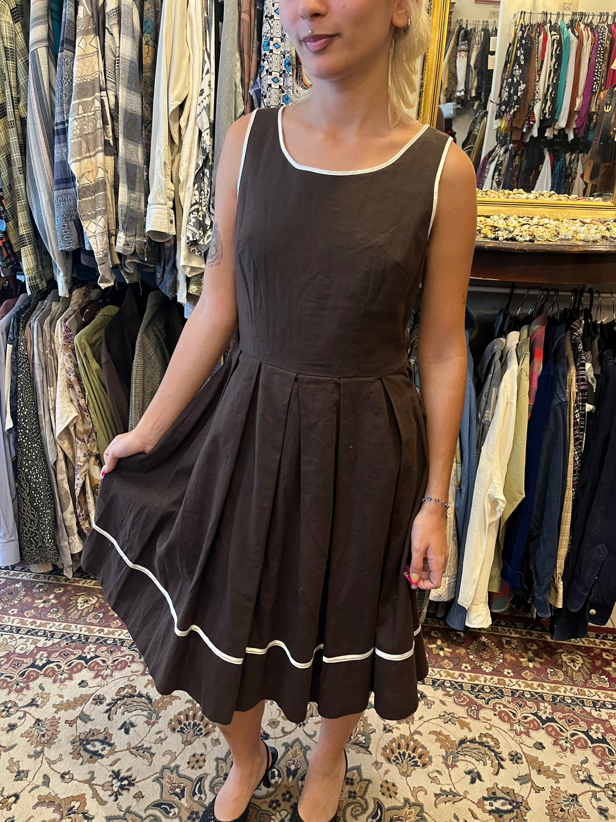 Elegant vintage-inspired wrap midi dress with a geometric print, contrasting black lapels and a tie waist. A timeless statement piece with a flattering silhouette and effortlessly chic feel.