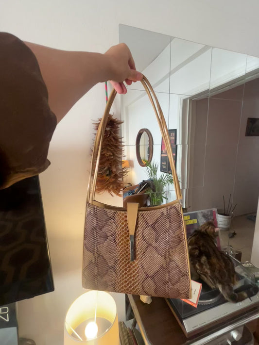 Vintage 90s Snakeskin Print Shoulder Bag
Statement structured shoulder bag in warm brown and gold tones, featuring a snakeskin-effect finish, long slim straps and elegant metallic detailing.